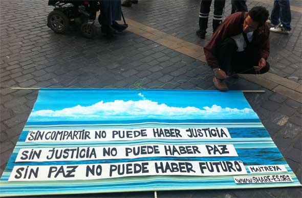 Un seguidor de Maitreya prepara una pancarta antes de la asamblea de los 'indignados' del jueves en Bilbao. Foto: L.A. Gámez.