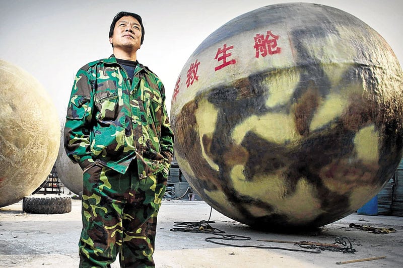 El granjero chino Liu Qiyuan, junto a una de las bolas salvavidas que construyó en el jardín de su casa a modo de arcás de Noé. Foto: AFP.