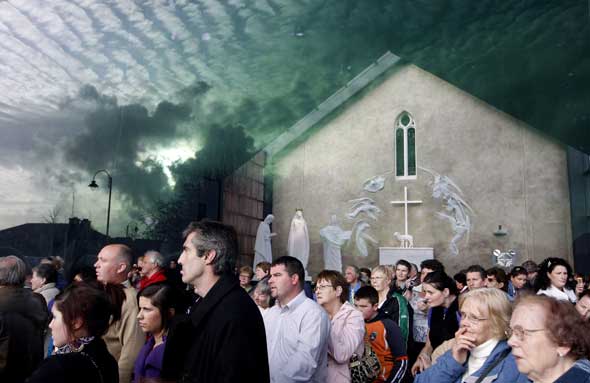 Imagen de la multitud en el santuario de Nuestra Señora de Knock, tomada con el cielo reflejándose en un cristal. Foto: AP.