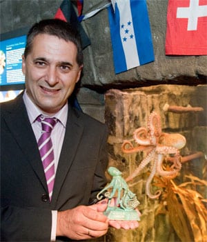 Carlos Montes, alcalde de O Carballiño, posa con una figurilla de bronce de un pulpo junto al tanque del 'cefalópodo adivino' en Oberhausen. Foto: Efe.