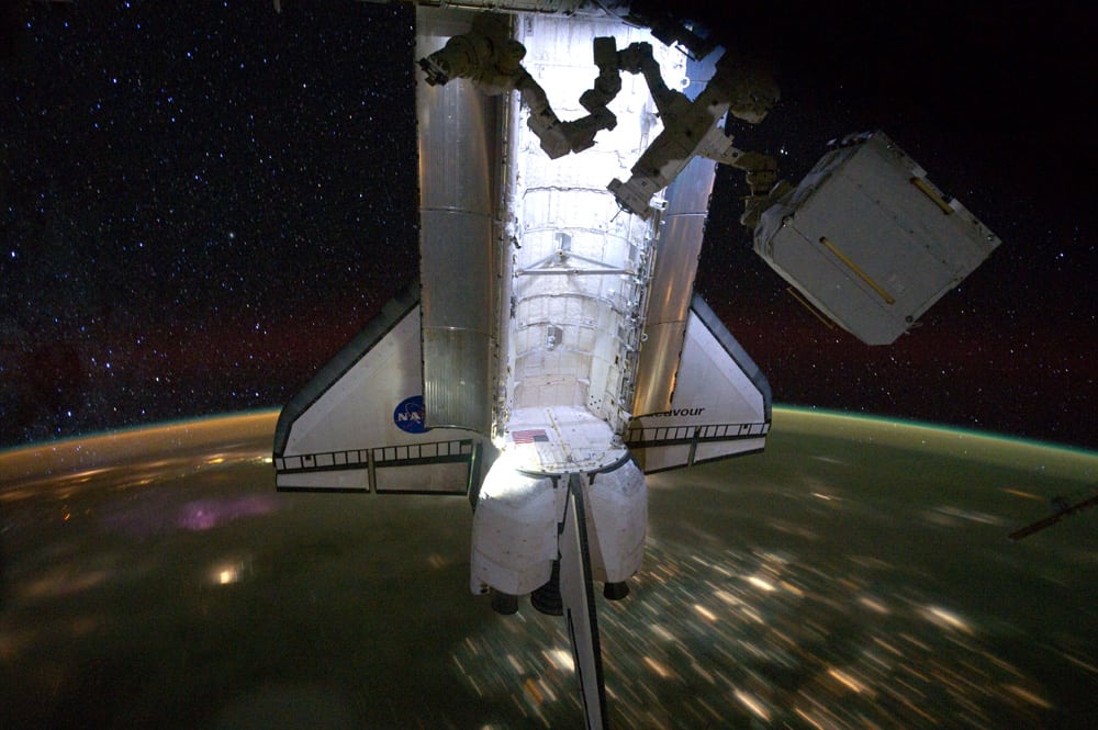El 'Endeavour', atracado en la ISS, volando sobre ciudades iluminadas y bajo un  cielo estrellado. Foto: NASA.