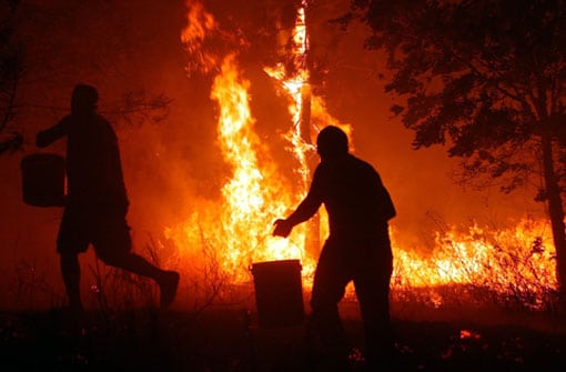 Dos vecinos se enfrentan a las llamas cerca de Orense. Foto: Efe.