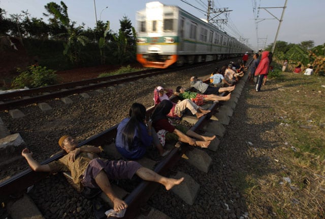 Vecinos de Rawa Buaya, en Indonesia, tumbados en la vías del tren para curarse de sus males. Foto: Reuters.
