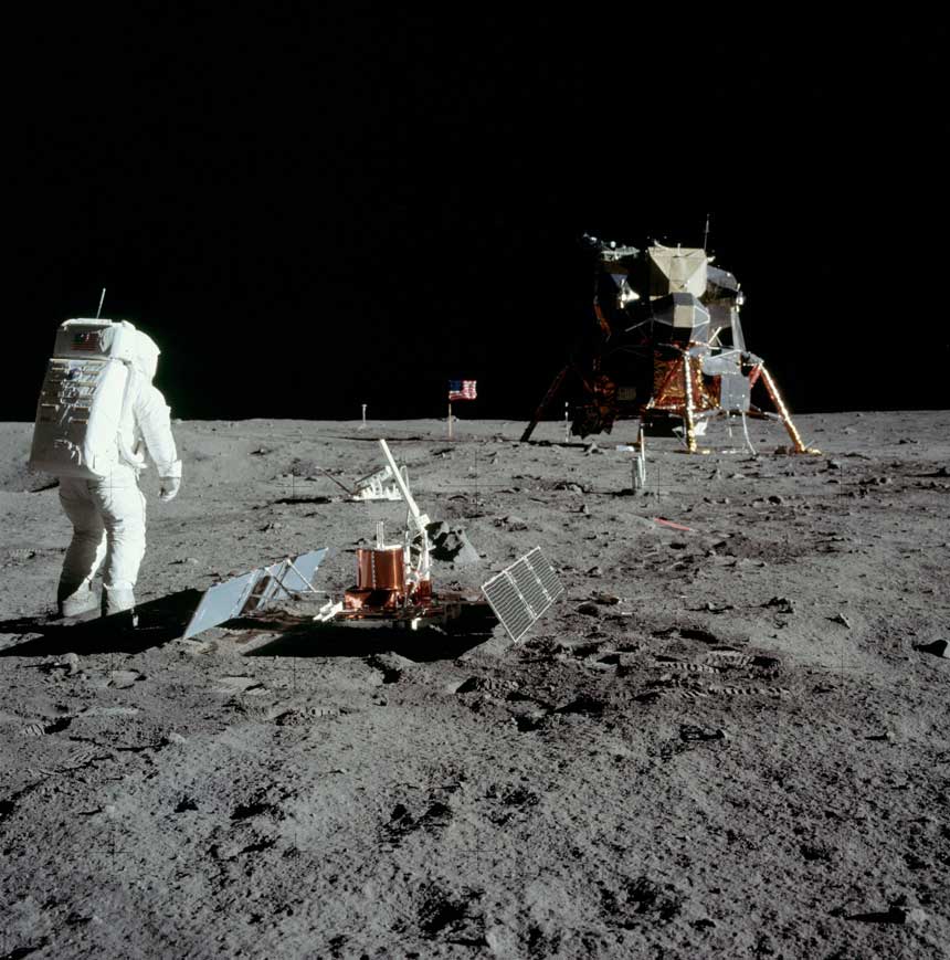 Buzz Aldrin en el mar de la Tranquilidad, junto al seismómetro, con el módulo lunar y la bandera al fondo. Foto: NASA.