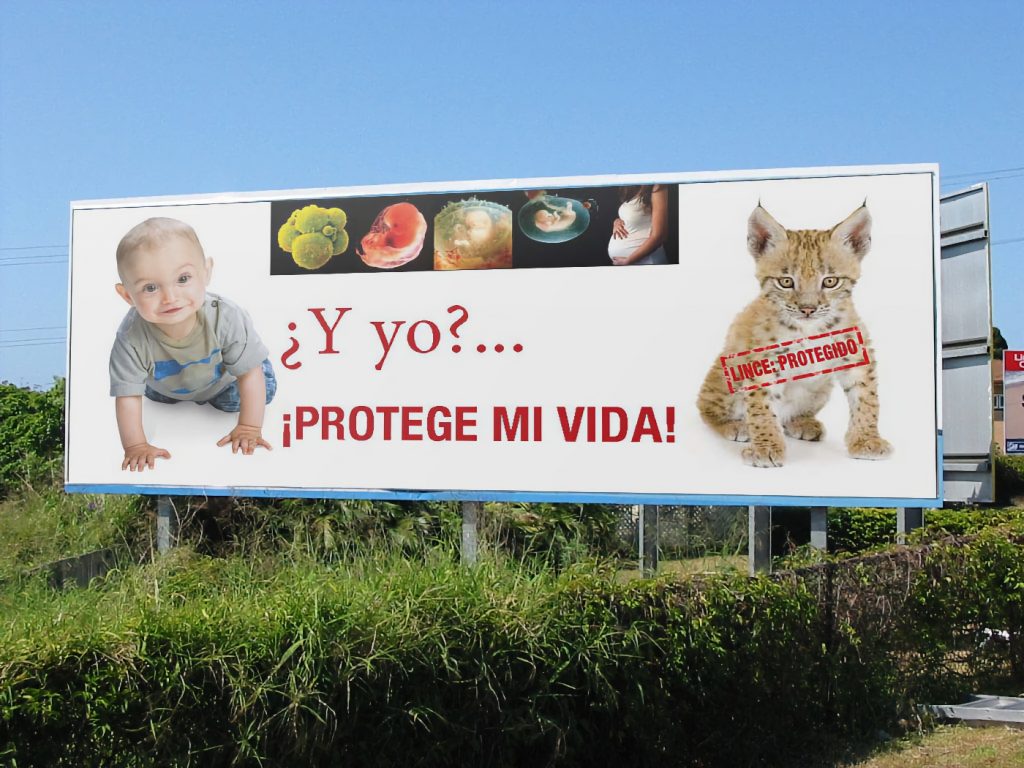 Una de las vallas publicitarias en las que la Iglesia católica española presenta a un niño que gatea como si estuviera desprotegido por la Ley. Foto: Conferencia Episcopal Española.